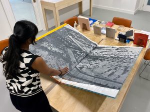 Nick Goss Large artist book being opened by study librarian Yamuna Ravindran